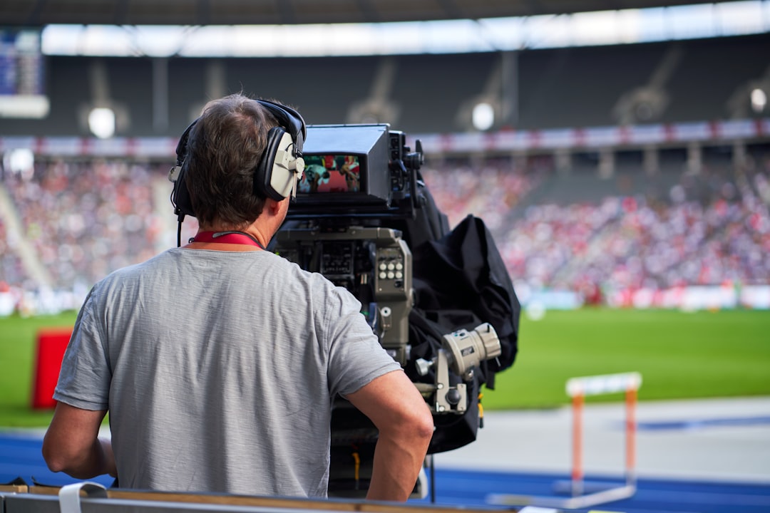 Cameraman at sports event capturing track and field athletes