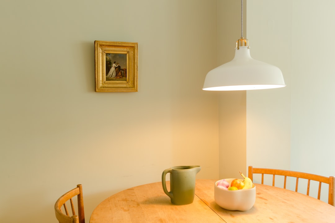interior with vase on table, fruit bowl, lamp and painting